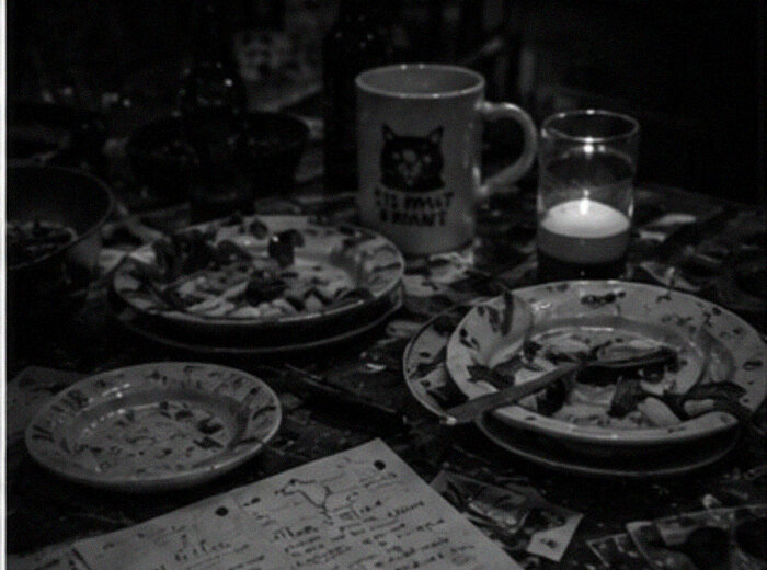 after dinner — notes, food, candles, the cat mug